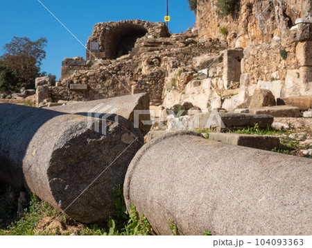 Fragments of a granite column against the backdrop of the ruins of the ancient city of Syedra, Mediterranean coast, South Turkey 104093363