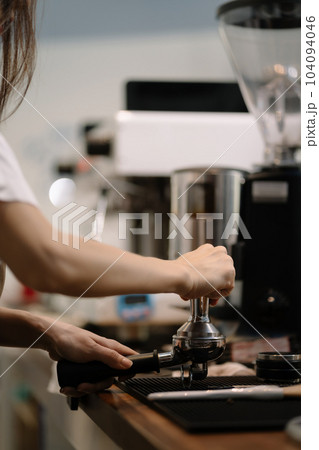 Young barista making coffee, coffee preparation service concept. 104094046