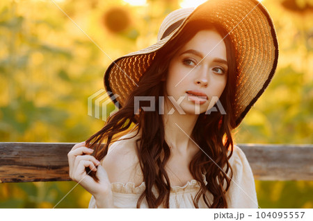Beautiful woman in a dress in a field of sunflowers 104095557