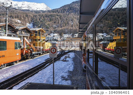 Trains on railroad track at railway station with beautiful view of pine trees on matterhorn in background at Zermatt, Switzerland, winter holiday travel concept 104096401