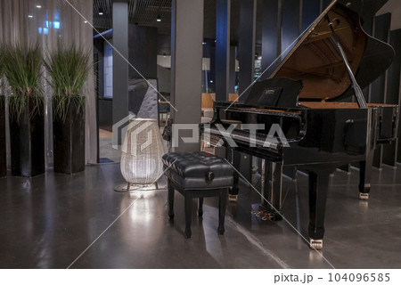 Piano with black stool placed by columns in fancy luxurious tourist resort, luxury travel concept Piano with black stool placed by columns in fancy luxurious tourist resort, luxury travel concept 104096585