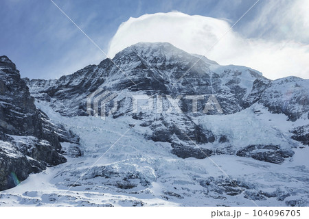Tranquil and beautiful view of majestic snow covered Bernese mountains with cloudy sky in background at Jungfrau, Switzerland, winter holiday and nature concept 104096705