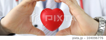Hands of doctor cardiologist hold red toy heart in air 104096776