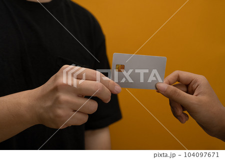 Man small business owner holding credit card isolated on yellow background. Electronic money, contactless payment concept 104097671
