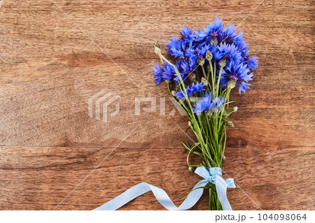 Blue cornflowers, bouquet picked in summer on wooden background. 104098064