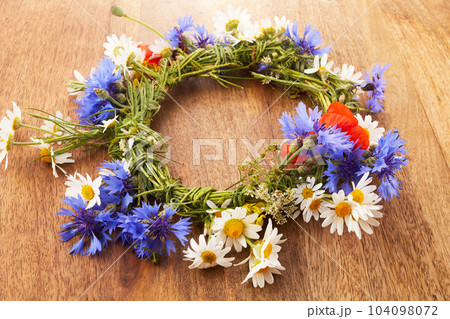 Wreath of chamomile flower on vintage background. Midsummer holiday background Wreath of chamomile flower on vintage background. Midsummer holiday background 104098072