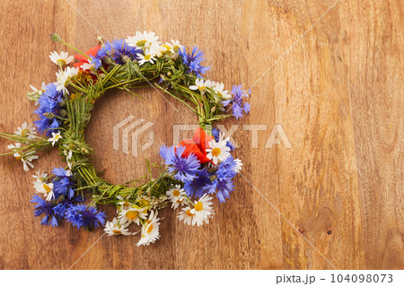 Wreath of chamomile flower on vintage background. Midsummer holiday background 104098073