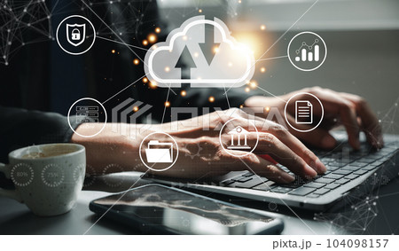 Virtual screen with cloud computing diagram in the hands of a man. Data storage, networking, and internet service concept. Laptop and network server in the background symbolize computer technology. 104098157