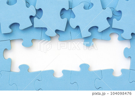 Four blue puzzle pieces revealing white background 104098476