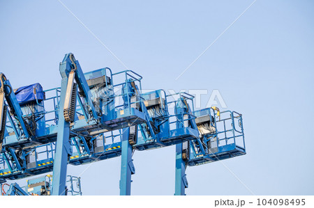 Articulated boom lift. Aerial platform lift. Telescopic boom lift against clear sky. Mobile construction crane for rent and sale. Maintenance and repair hydraulic boom lift service. Crane dealership. 104098495