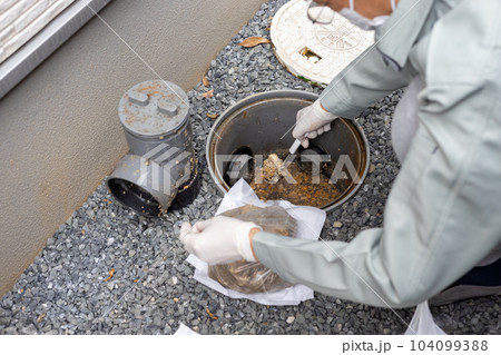 一戸建て住宅の外の汚水桝を掃除しているところ 104099388