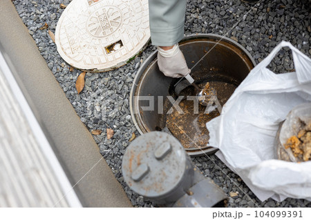 一戸建て住宅の外の汚水桝を掃除しているところ 104099391