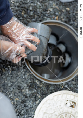 一戸建て住宅の外の汚水桝を掃除しているところ 104099394