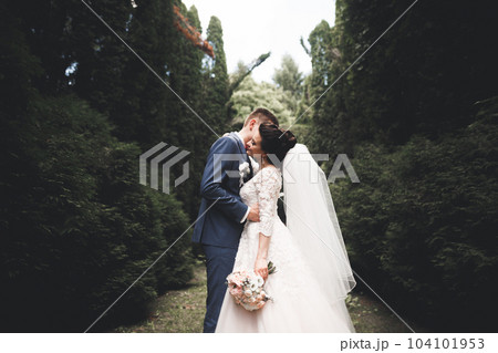 Newly married couple running and jumping in park while holding hands Newly married couple running and jumping in park while holding hands 104101953
