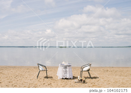 Table and chair for a romantic dinner by the sea, lake or ocean for a honeymoon Table and chair for a romantic dinner by the sea, lake or ocean for a honeymoon 104102175