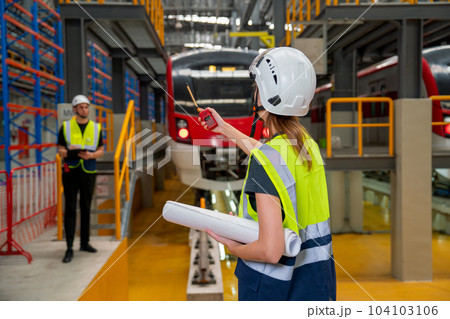 Back of technician or engineer worker woman use walkie talkie point to her co-worker during work Back of technician or engineer worker woman use walkie talkie point to her co-worker during work 104103106