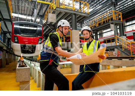 Wide shot of engineer worker woman sit and hold drawing paper to discuss with technician Wide shot of engineer worker woman sit and hold drawing paper to discuss with technician 104103119