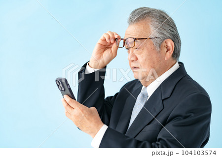 スマホを見るシニア男性 老眼 スマホを見るシニア男性 老眼 104103574