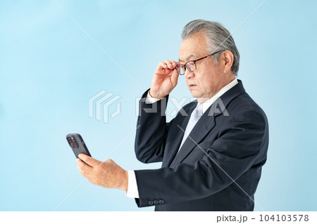 スマホを見るシニア男性 老眼 スマホを見るシニア男性 老眼 104103578