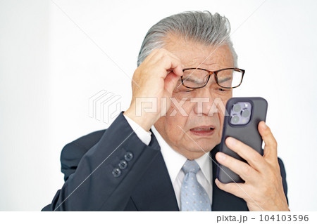スマホを見るシニア男性 老眼 スマホを見るシニア男性 老眼 104103596