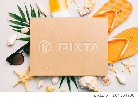 Summer time concept with blank greeting card and blank craft paper on colored background. Seashells from ocean shore in the shape of frame separated with space for text top view Summer time concept with blank greeting card and blank craft paper on colored background. Seashells from ocean shore in the shape of frame separated with space for text top view 104104530