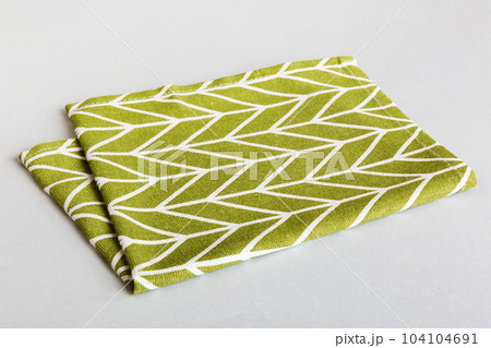top view with green kitchen napkin isolated on table background. Folded cloth for mockup with copy space, Flat lay. Minimal style top view with green kitchen napkin isolated on table background. Folded cloth for mockup with copy space, Flat lay. Minimal style 104104691