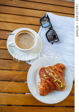 Cozy cafe moment with croissant, coffee, and magazine Cozy cafe moment with croissant, coffee, and magazine 104107441