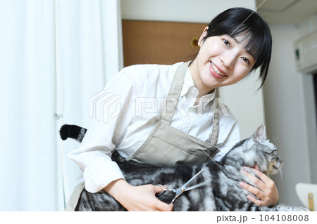 猫の毛並みをハサミで整えるトリマーの女性 104108008