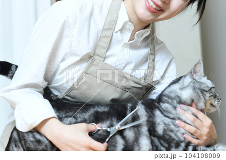 猫の毛並みをハサミで整えるトリマーの女性 104108009