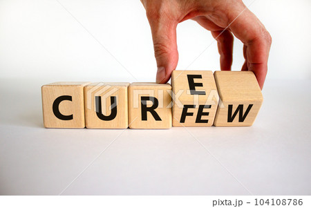 Curfew and cure symbol. Businessman turns cubes and changes the word 'curfew' to 'cure'. Beautiful white background. Business, curfew and cure concept. Copy space. Curfew and cure symbol. Businessman turns cubes and changes the word 'curfew' to 'cure'. Beautiful white background. Business, curfew and cure concept. Copy space. 104108786