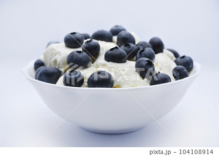 Ice cream with berries. Ice cream in a ceramic bowl. Ice cream and blueberries. 104108914