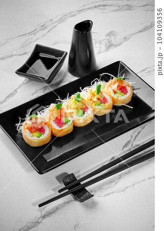 Rolls in mamenori with salmon, tuna, avocado, sea scallop served with daikon 104109356