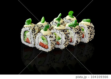 Salmon Philadelphia rolls in sesame topped with mayonnaise and greens on black Salmon Philadelphia rolls in sesame topped with mayonnaise and greens on black 104109366