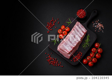 Raw pork ribs with meat with salt, spices and herbs 104110345