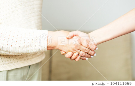 Doctor or nurse shaking hands with a senior woman at home. Doctor or nurse shaking hands with a senior woman at home. 104111669