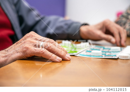 Close up of a senior man playing bingo at Nursing home. leisure game, support, assisted living, and 104112015