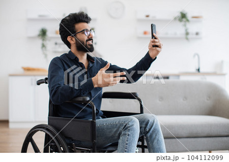 Person with disability chatting via video call at home Person with disability chatting via video call at home 104112099