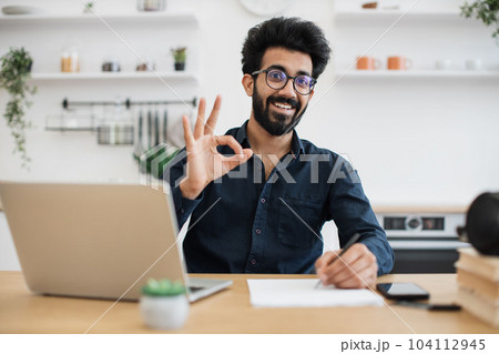 Businessman posing with digital devices in dining room Businessman posing with digital devices in dining room 104112945