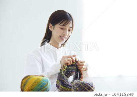 リビングにて趣味の手芸で毛糸を編む30代の日本人女性 104115849