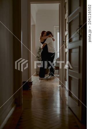 Romantic couple hugging and enjoying time together while standing at home. Good relationship time 104116502