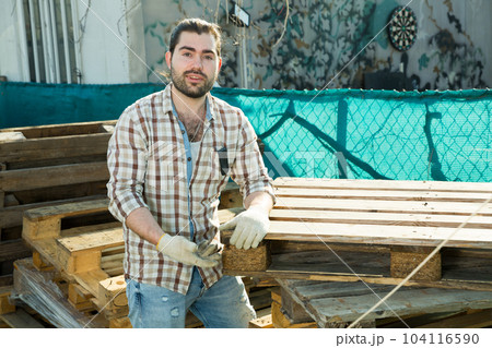 Man moving wooden pallets Man moving wooden pallets 104116590