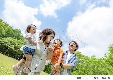 公園の広場で遊ぶ4人家族 104116816