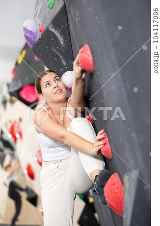 Young woman practicing rock climbing on climbing wall Young woman practicing rock climbing on climbing wall 104117006