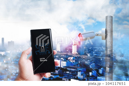 Smartphone screen in hand  displaying a cyber CCTV security concept with a cityscape 104117651