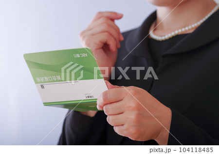 通帳を見つめる喪服姿の女性 通帳を見つめる喪服姿の女性 104118485