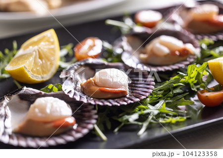 Saint Jacob mussels made in an Italian restaurant served on a plate and shells of the scallops Saint Jacob mussels made in an Italian restaurant served on a plate and shells of the scallops 104123358