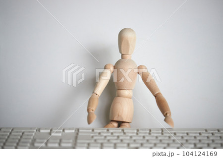 木製のマネキン人形とパソコンのキーボード 木製のマネキン人形とパソコンのキーボード 104124169