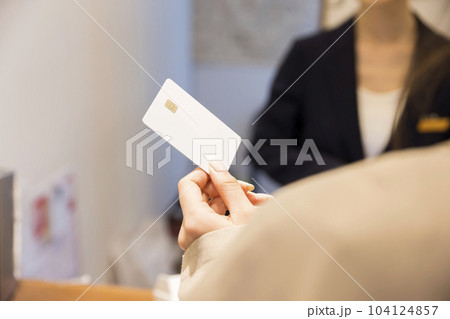ホテルフロントでクレジットカードを出す若い女性手元 104124857