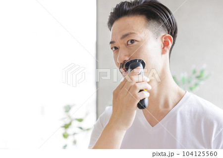 電気シェーバーで髭を剃る男性 104125560