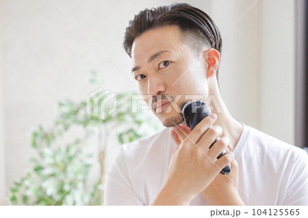 電気シェーバーで髭を剃る男性 104125565
